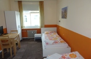 This room has two single beds, a washing facility in the room, a small seating area, a desk, TV with local channels and access to the shared bathroom and toilet.  Available from 48,- Euro/night. 